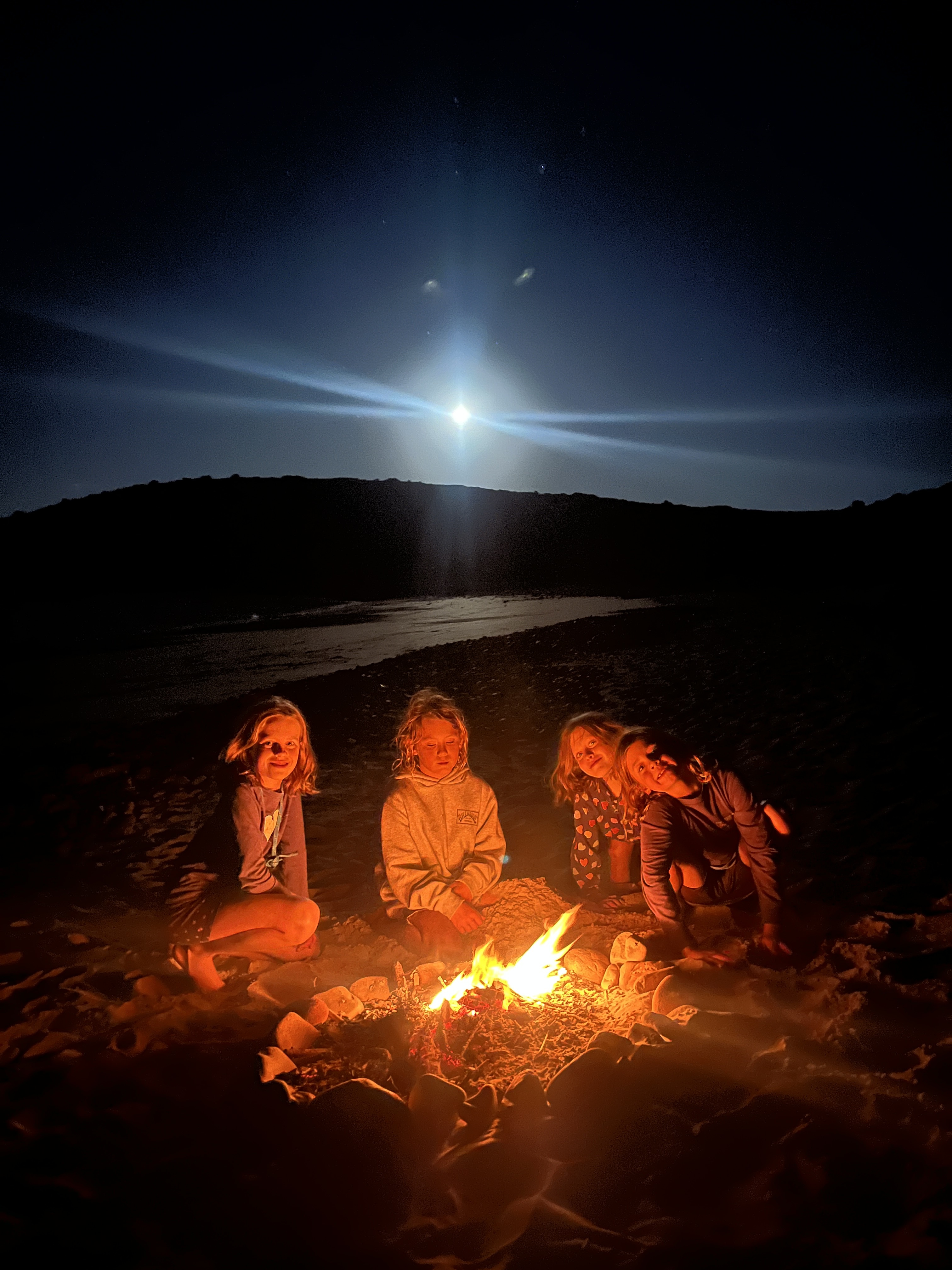 The full moon rise over a fire