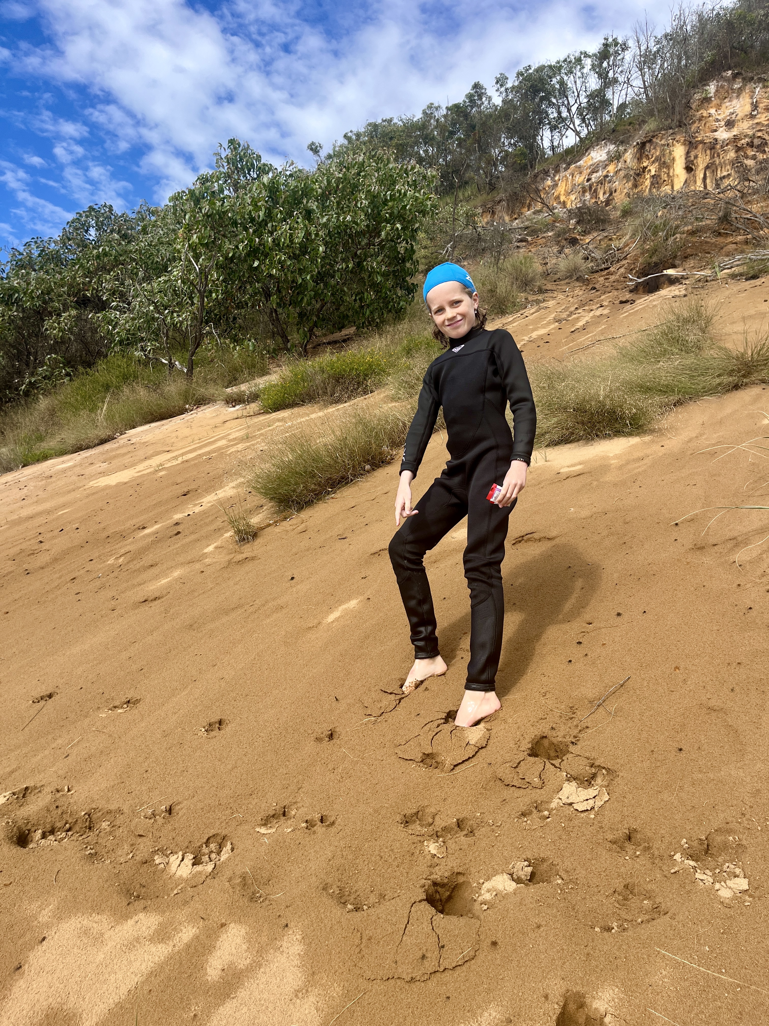 The dingo tracks lead down the beach along the bottom of the cliff